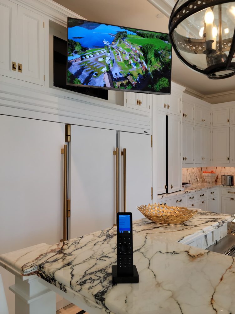 Wall-mounted television with a control remote in the foreground